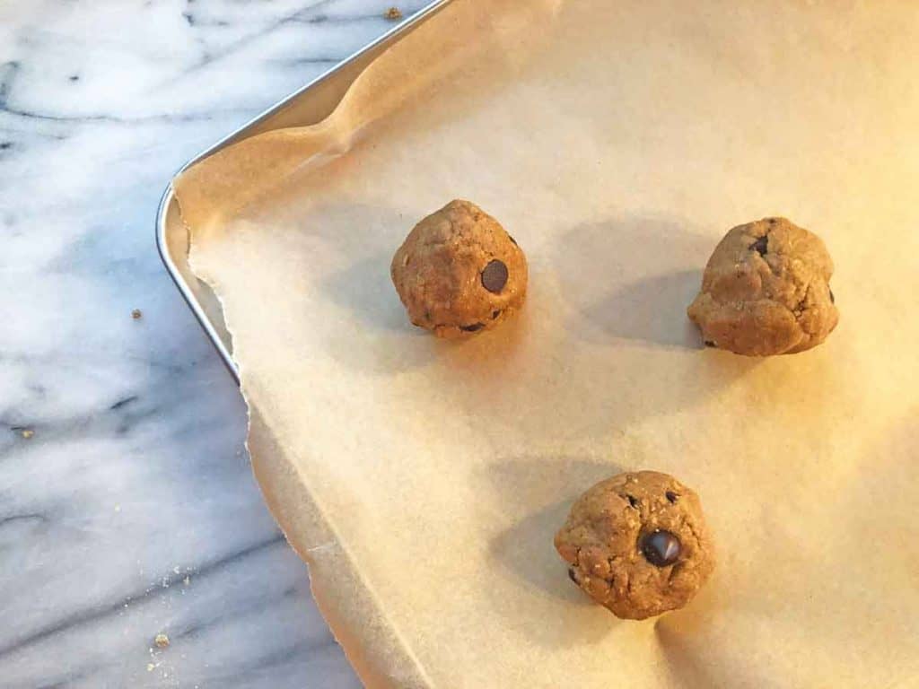 Vegan einkorn chocolate chip cookie dough is on a baking tray ready for the oven.