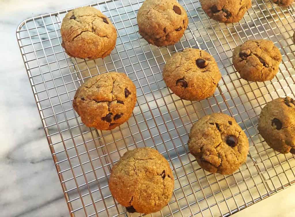 Vegan einkorn chocolate chip cookies are cooling on a wire rack.