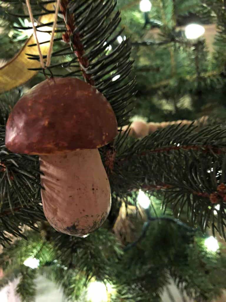 A mushroom ornament is on a live Christmas tree. 